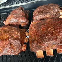 Multiple racks of ribs smoking on the BBQ Art Co. pit