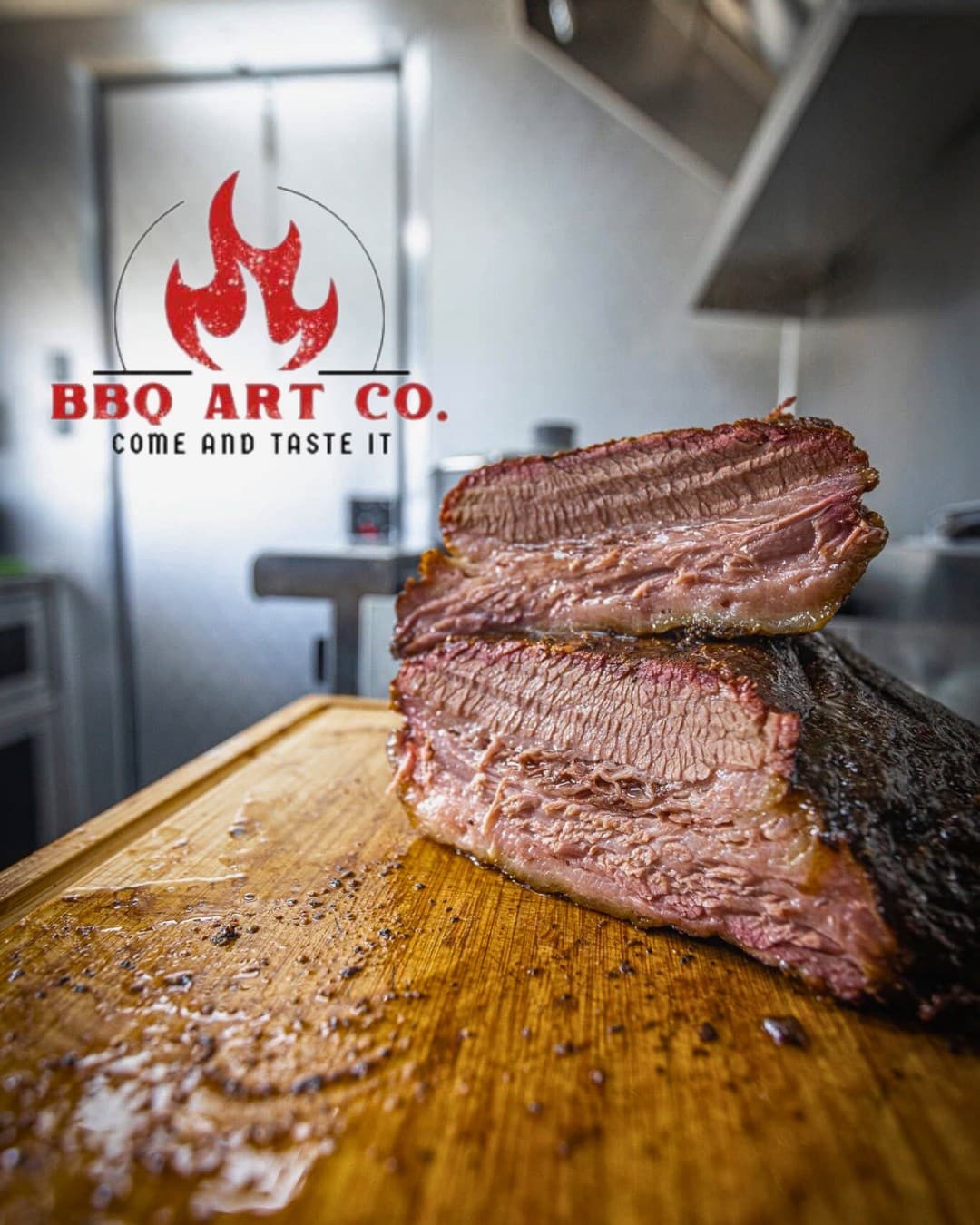 Halved BBQ Art Co. smoked brisket showing a deep smoke ring on the cutting board