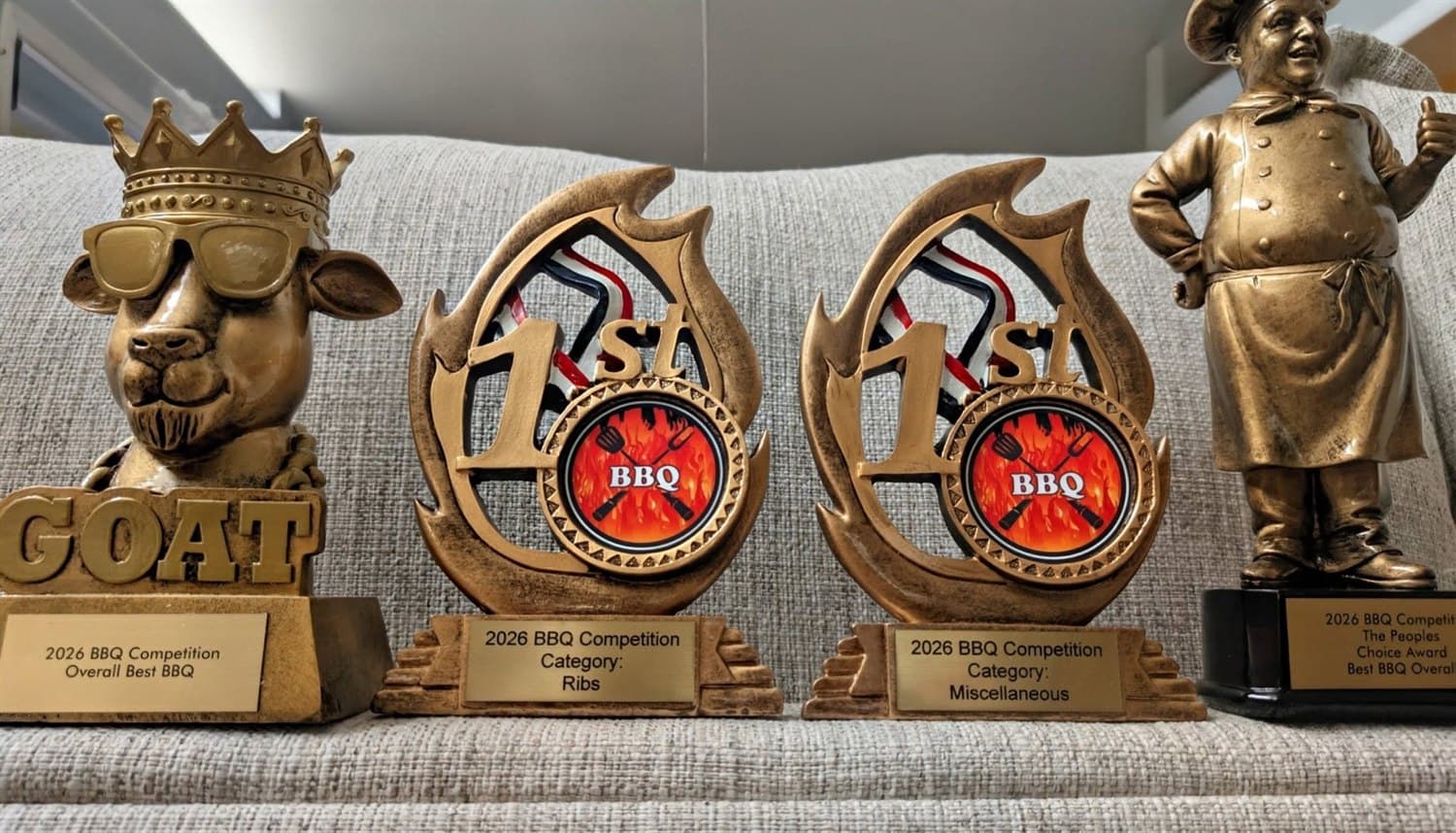 BBQ Art Co.'s four 2026 BBQ Competition trophies — Overall Best BBQ, 1st Place Ribs, 1st Place Miscellaneous, and the People's Choice Award
